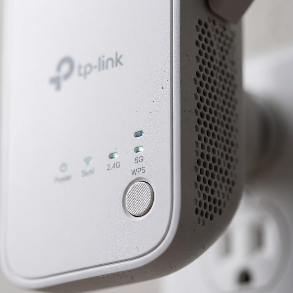 Close-up of TP-Link Wi-Fi range extender showing WPS button, status LED lights, and side air vents.